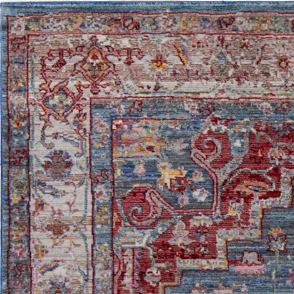 Top-down view of a traditional distressed rug featuring intricate red, blue, and cream floral patterns with a faded vintage look.