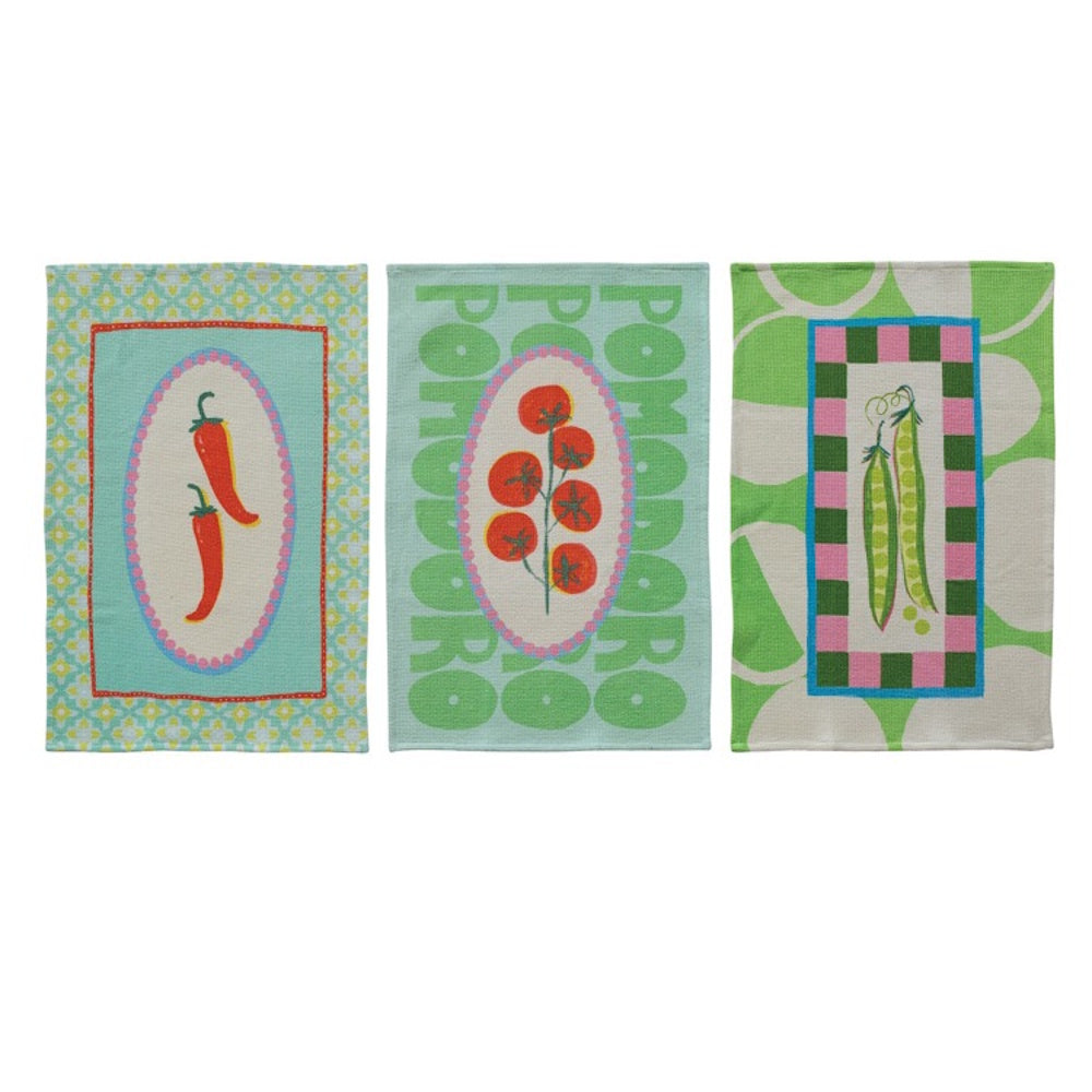 Three waffle-weave tea towels featuring colorful illustrations of red chili peppers, tomatoes, and green pea pods.