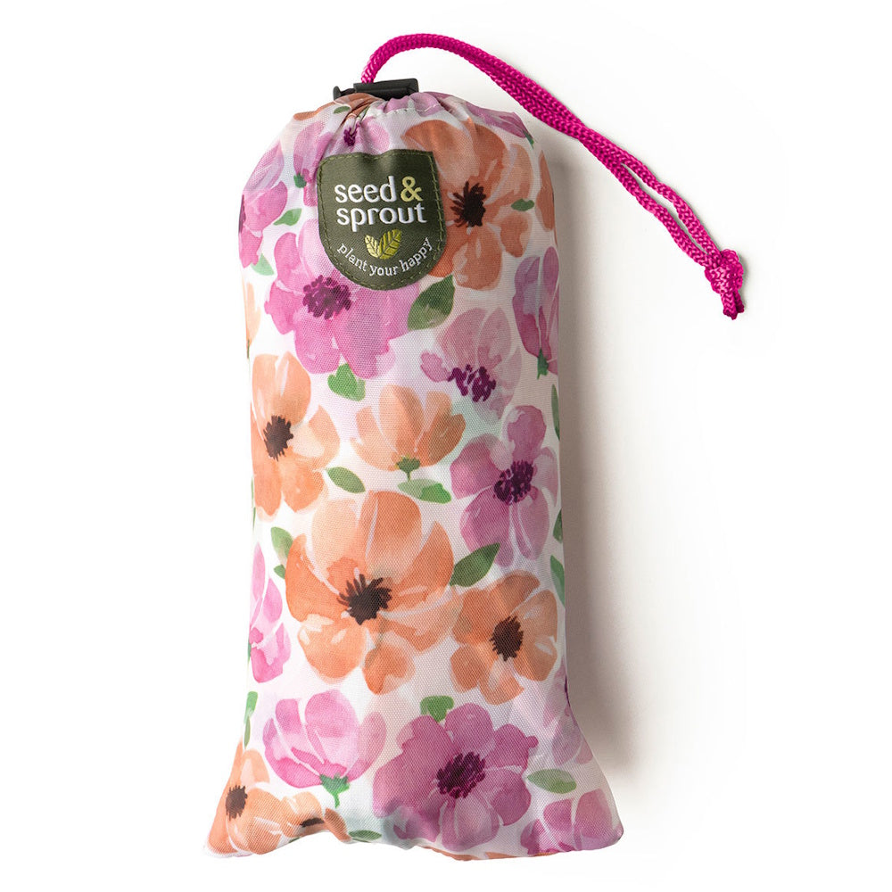 A floral-patterned drawstring pouch with a pink cord and a "seed & sprout" logo patch.