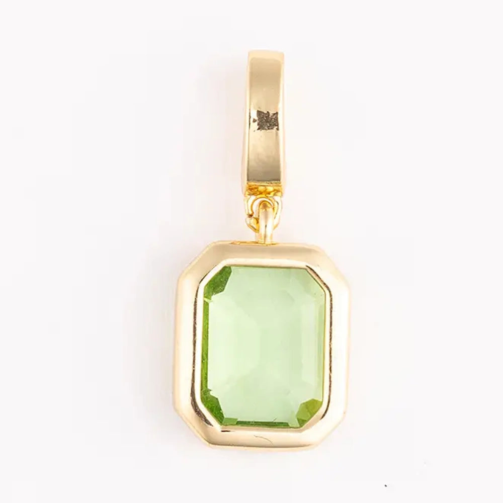 Gold pendant charm featuring an emerald-cut, light green gemstone in a polished bezel setting.