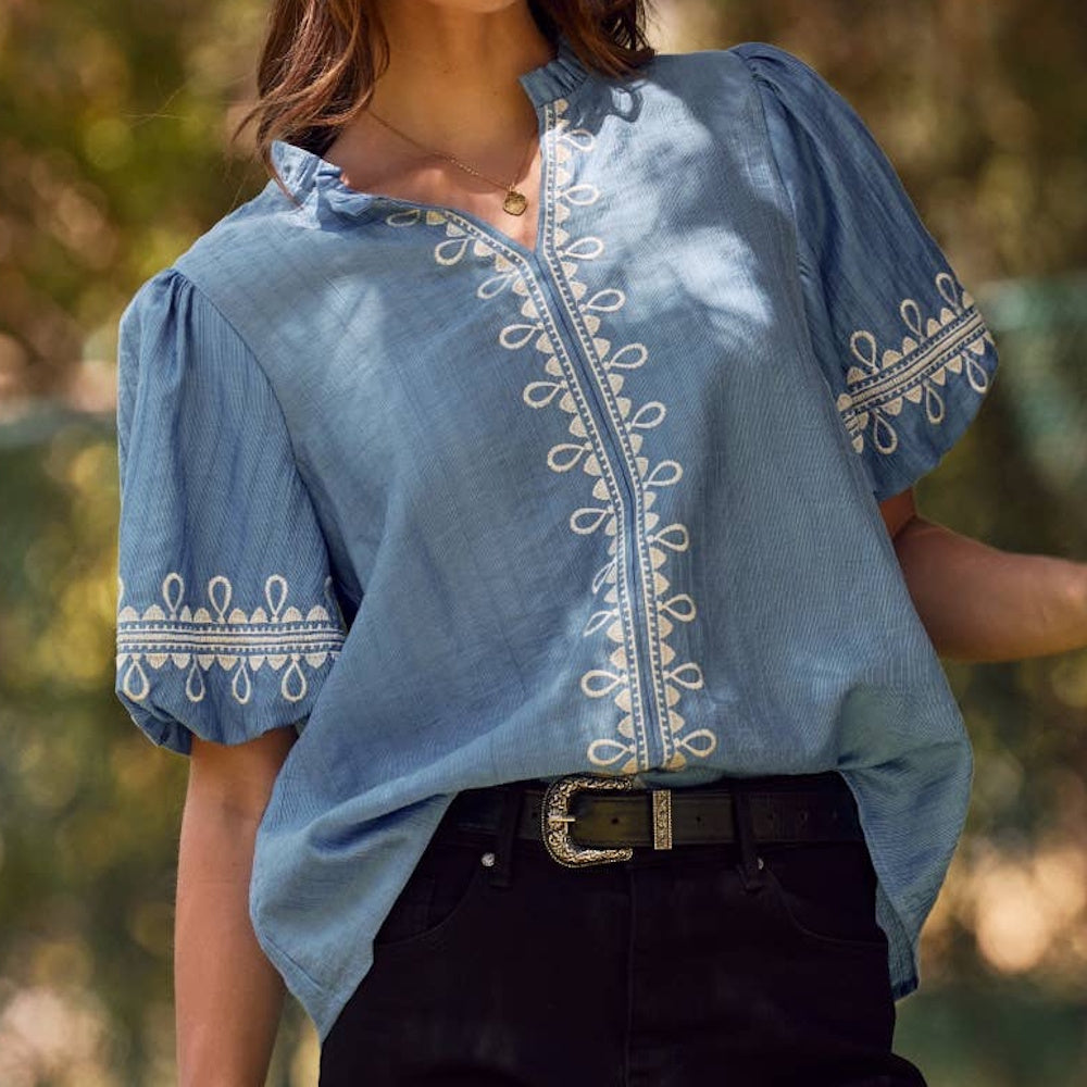 Azure blue split-neck blouse featuring white embroidery along the front placket and short bubble sleeves.