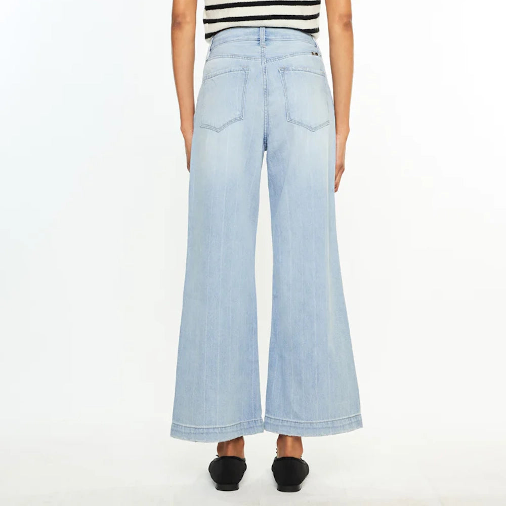 Back view of model wearing light wash 90s wide-leg jeans with back pockets and subtle vertical pinstripes.