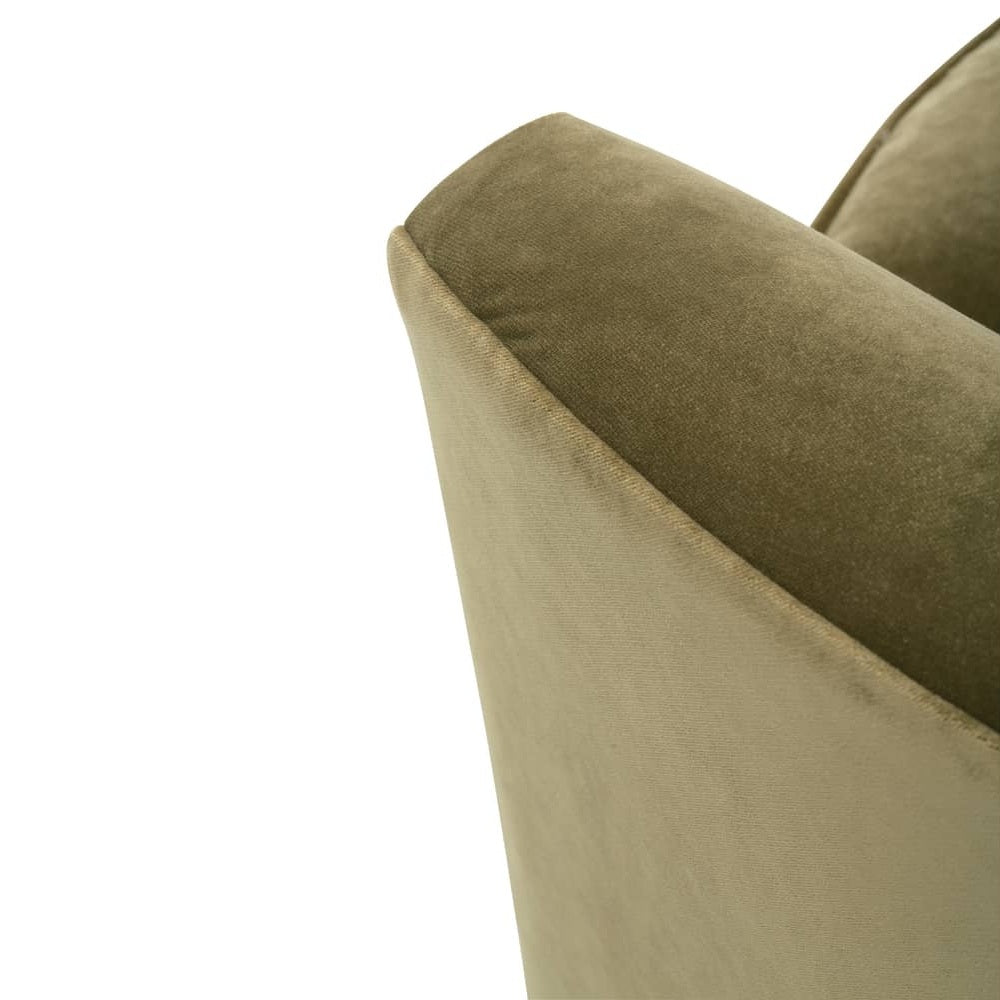 Close-up view of the back corner trim and smooth curved armrest on an olive green velvet chair.