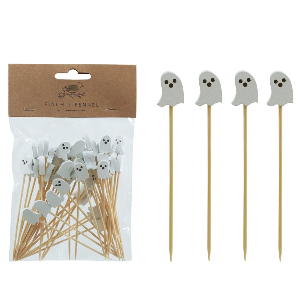 Wooden food picks topped with white ghost shapes next to a packaged set.