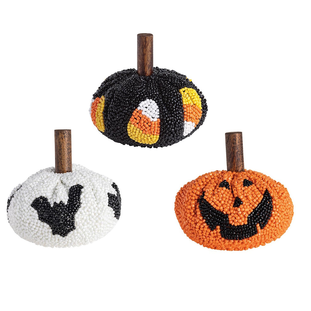 Three beaded pumpkins with wooden stems in candy corn, bat, and jack-o'-lantern designs.