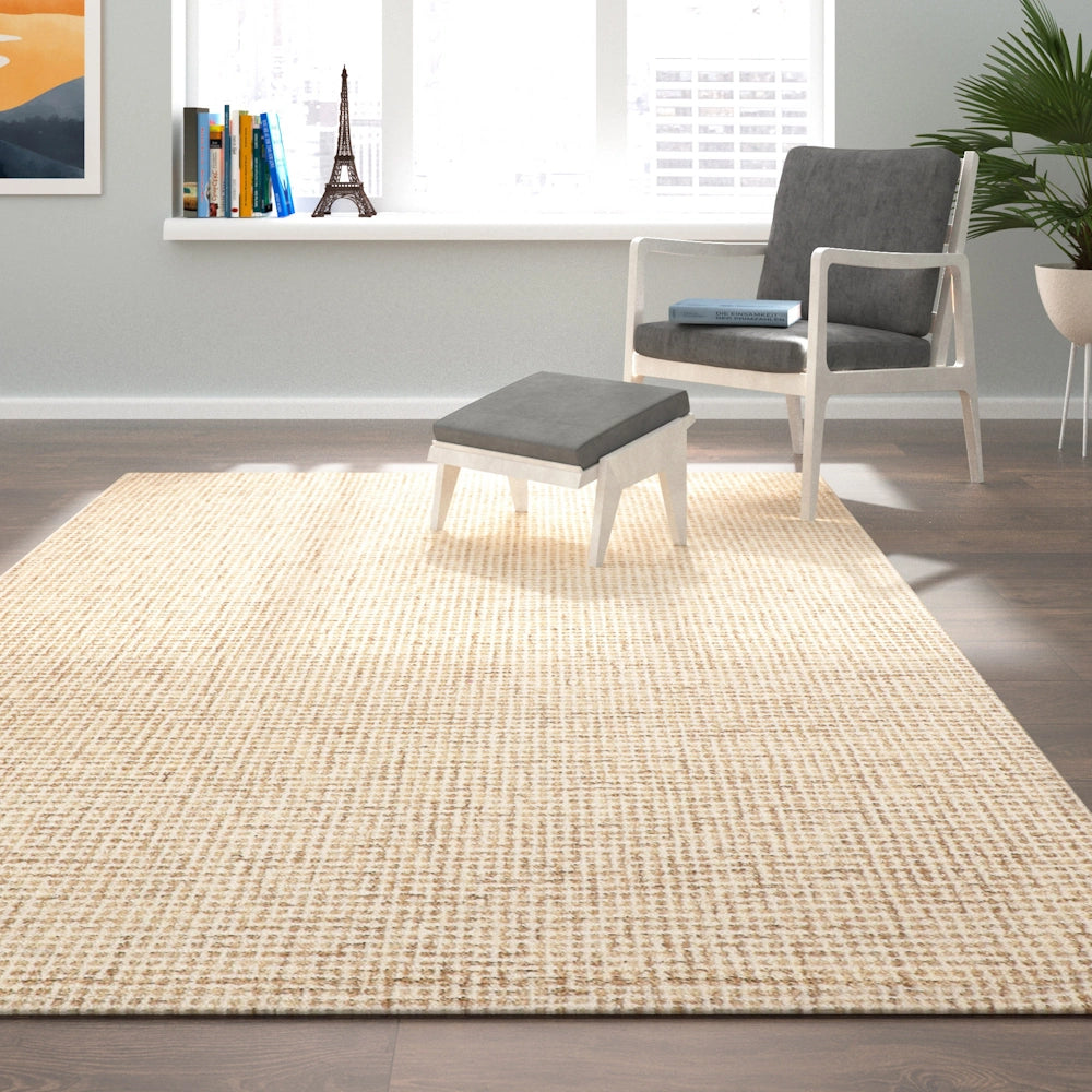 Modern neutral area rug in a sunlit living room with a grey accent chair and matching ottoman.