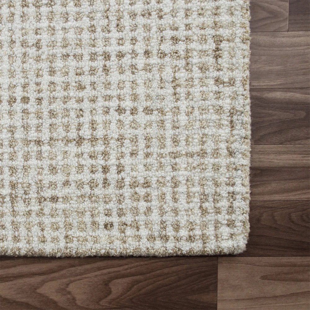 Cream textured hand-tufted wool rug with a grid pattern on a dark wood floor.