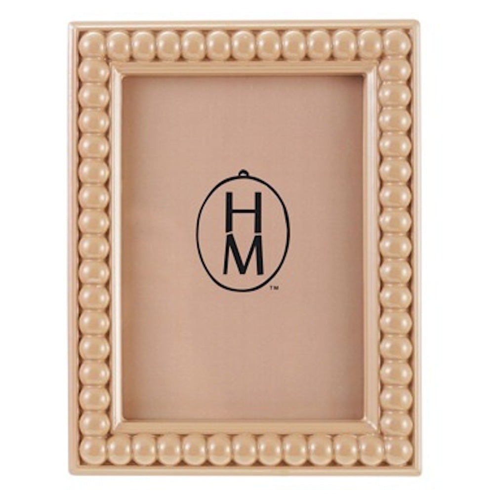 A glossy beige bobbin-style picture frame with a beaded border and a tan insert featuring a black "HM" logo.