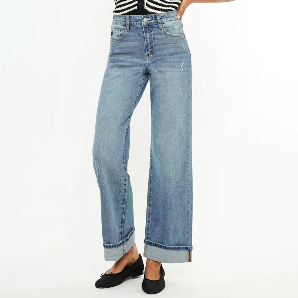High-rise wide-leg jeans in light wash denim with cuffed hems, paired with black ballet flats.