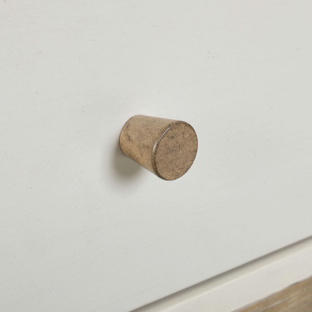 Close-up of round wood drawer knob on painted end table front.