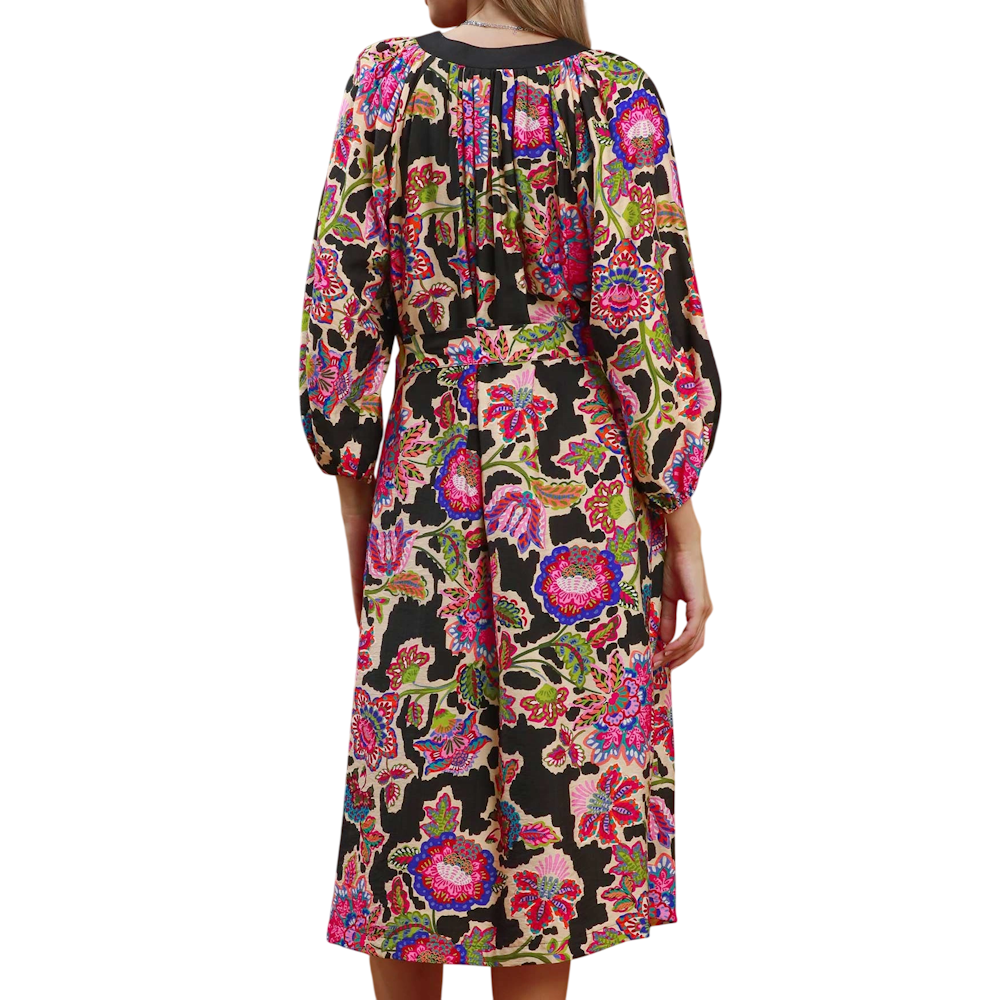 Back view of a midi dress featuring a colorful floral abstract print on a black background and long sleeves.