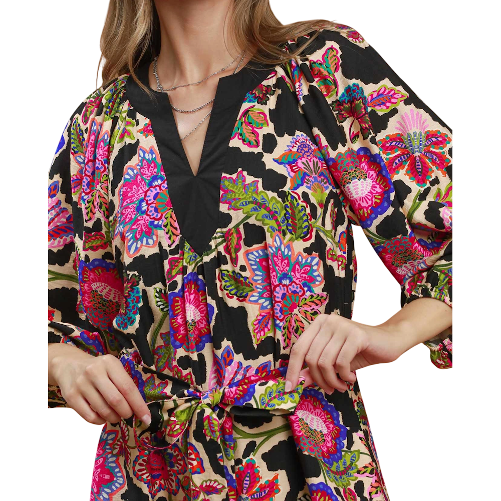 Black printed midi dress with vibrant pink, blue, and green floral pattern, a v-neckline, and a tie belt.