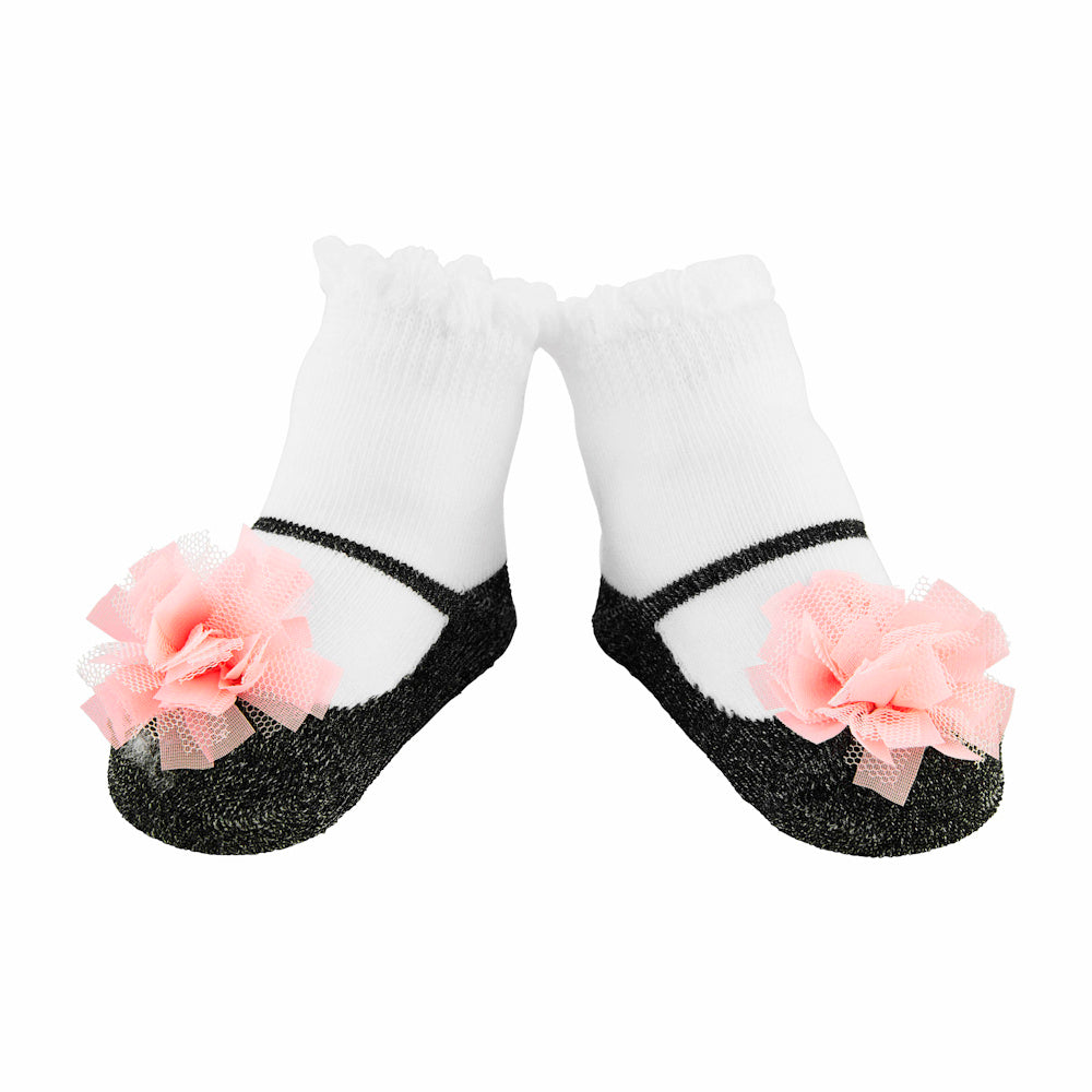 White baby socks with black Mary Jane shoe pattern and pink tulle flower accents on a white background.