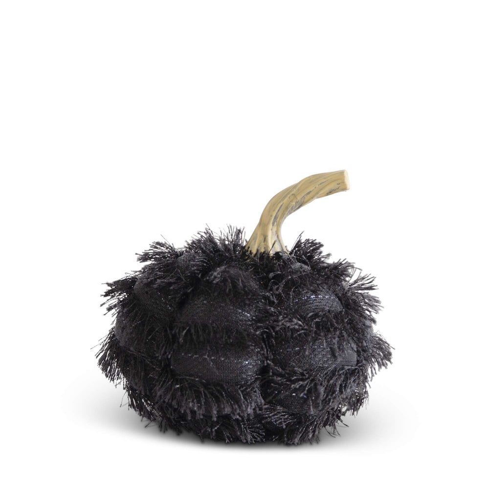 A small decorative black fabric pumpkin covered in shaggy eyelash fringe with a light beige curved stem.