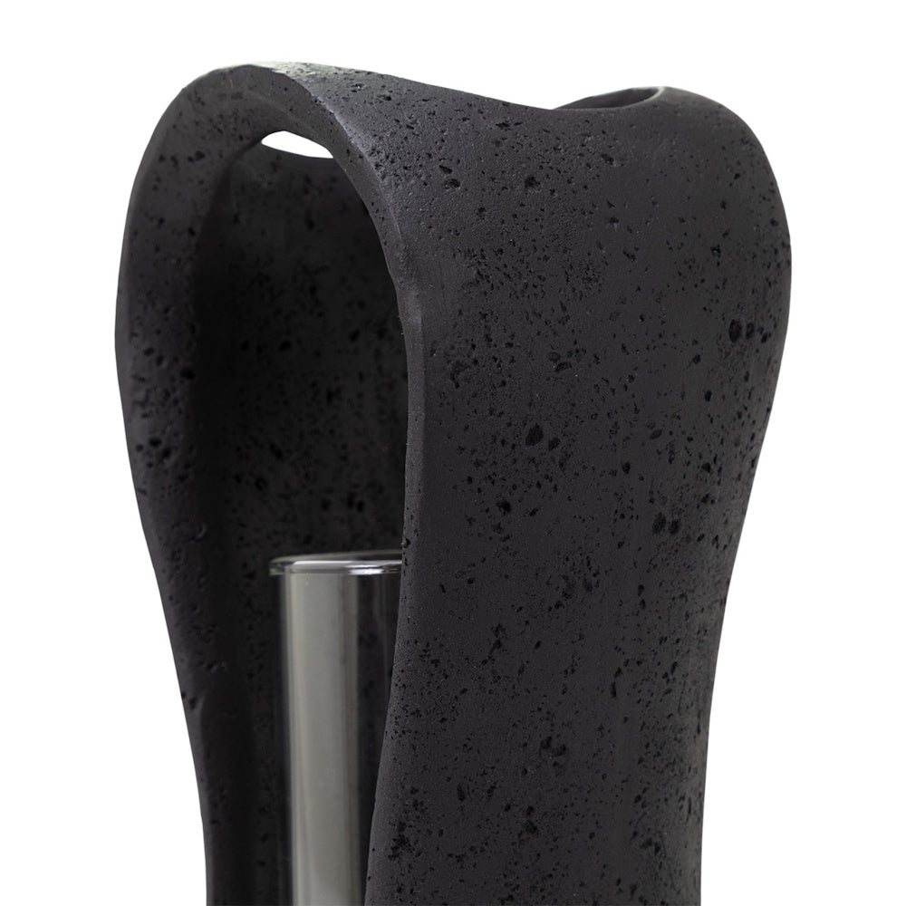 Close-up of a textured black Lestro hurricane candle holder with a lava-like stone finish and glass insert.