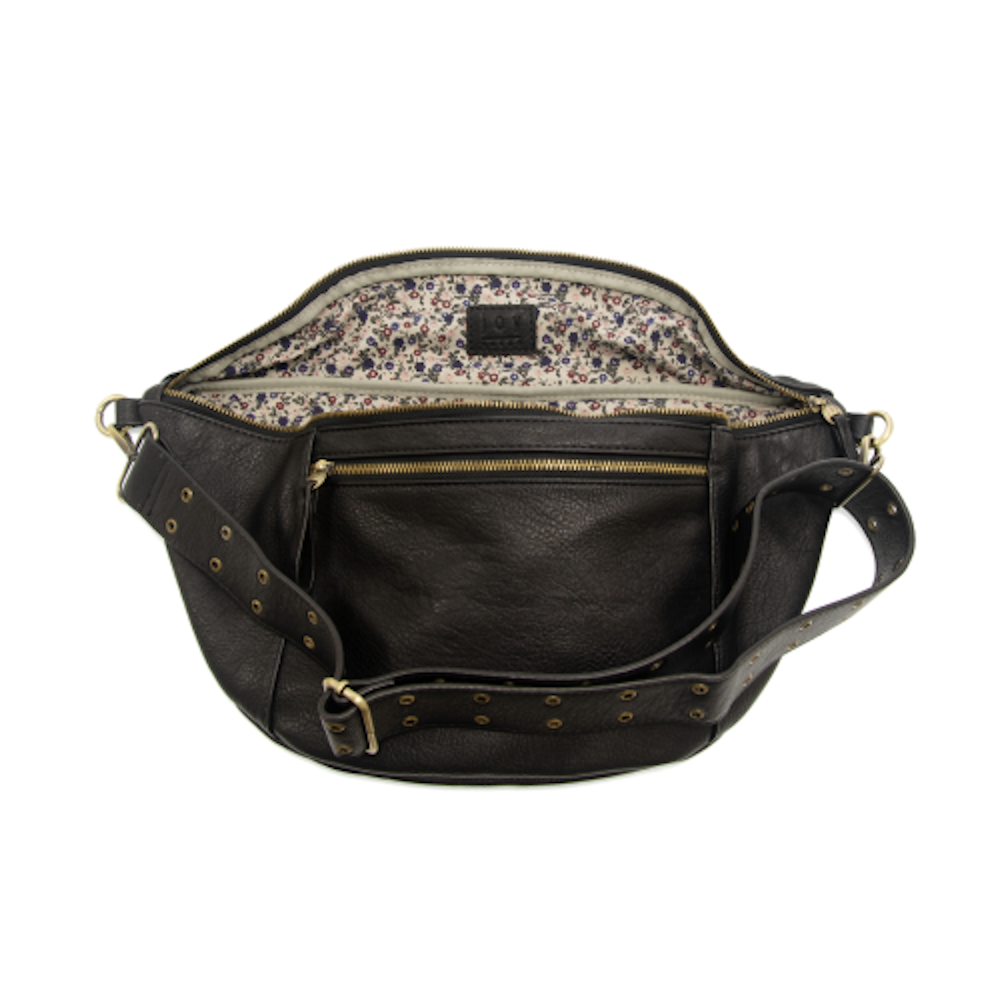 Open black leather crossbody fanny pack with floral lining and studded adjustable strap.