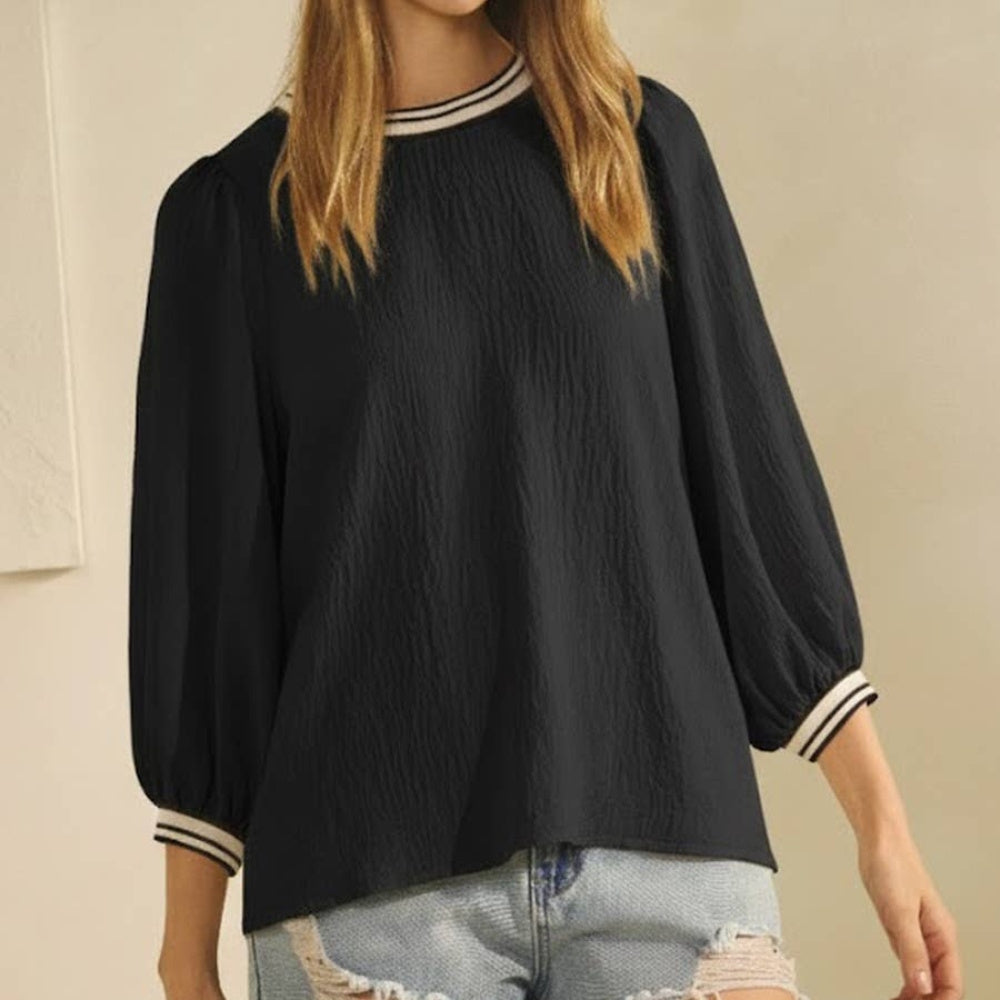 Black solid airflow top with puff sleeves and striped ribbing at the neckline and cuffs.