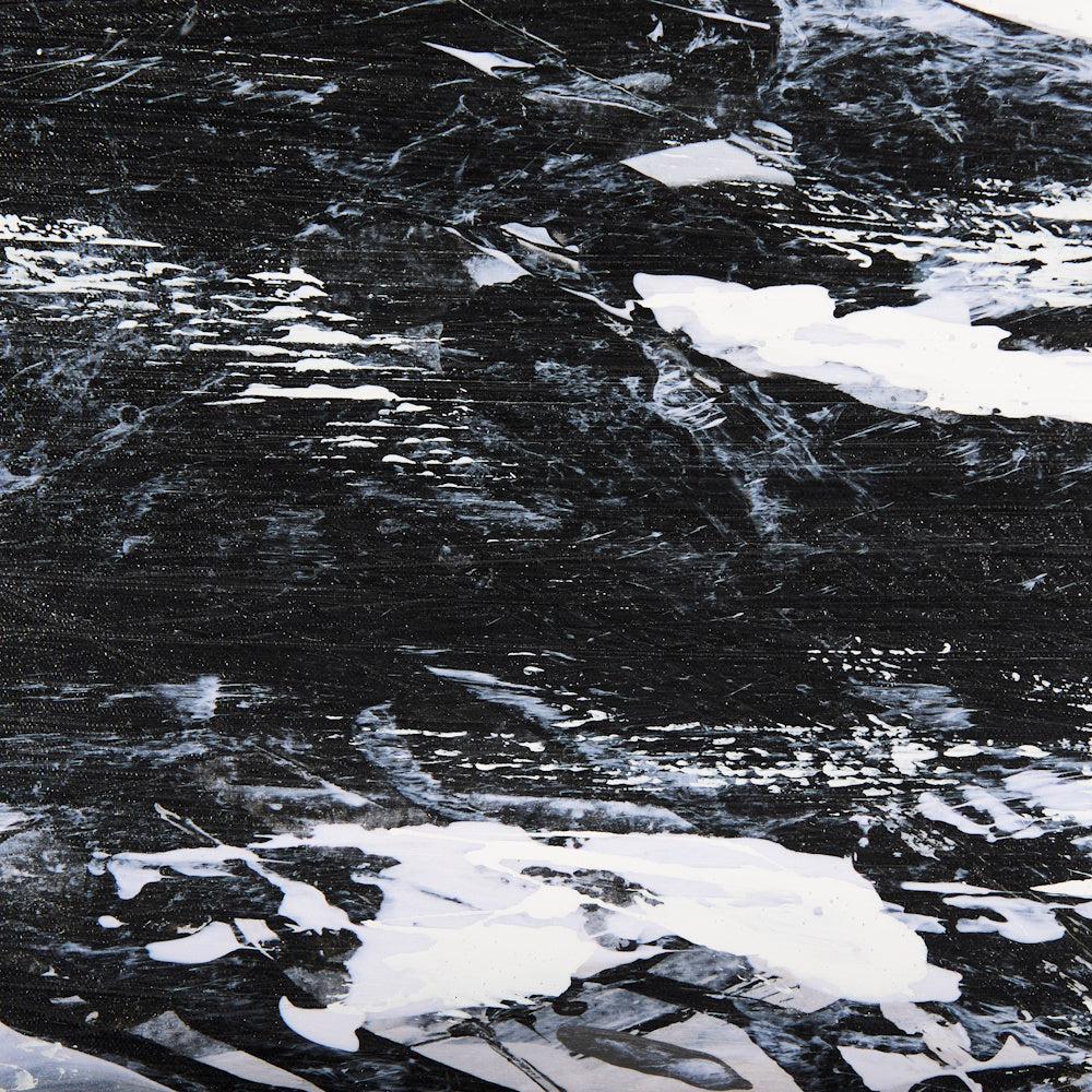 Extreme close-up of the bold black and white brushstrokes on the hand-embellished abstract canvas art.