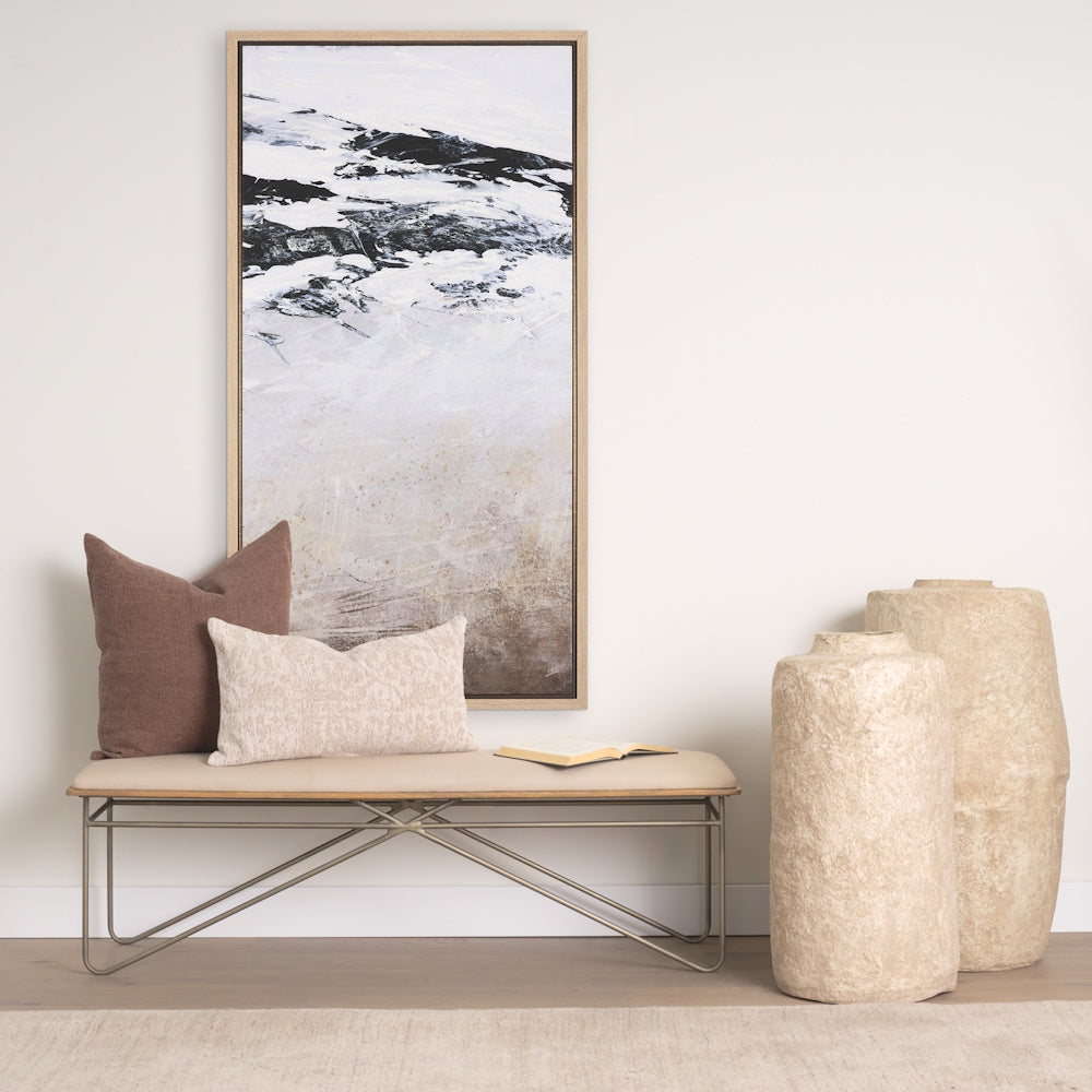 Lifestyle view of the framed abstract canvas hanging above a bench with pillows and textured vases.