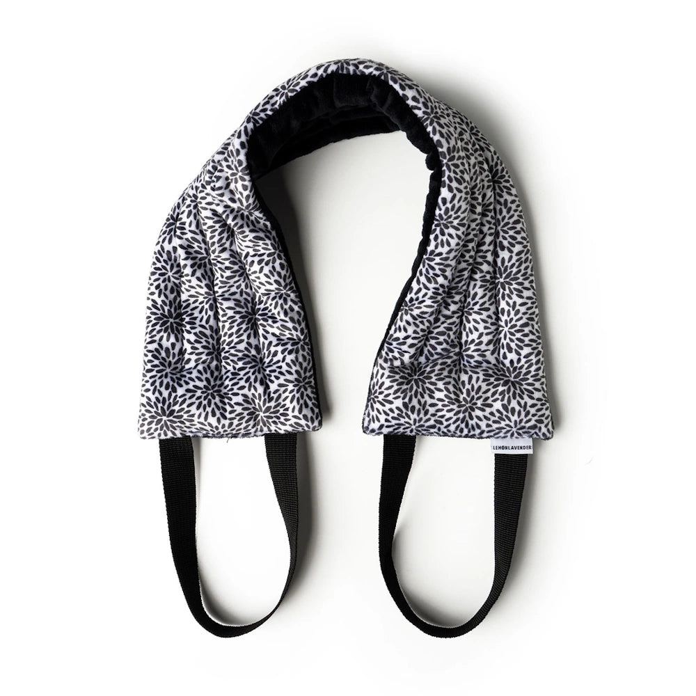 Lemon Lavender Hot Stuff heated neck wrap with black and white floral pattern, featuring black handles for easy positioning.