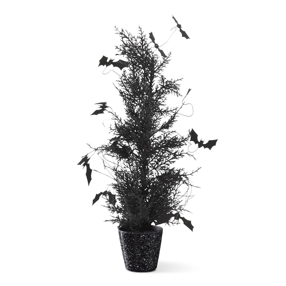 Spooky black Halloween potted pine tree decorated with purple glitter accents and flying bats.