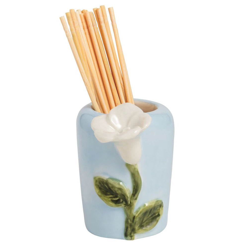 A light blue ceramic toothpick holder featuring a raised white flower and green stem, filled with wooden toothpicks.