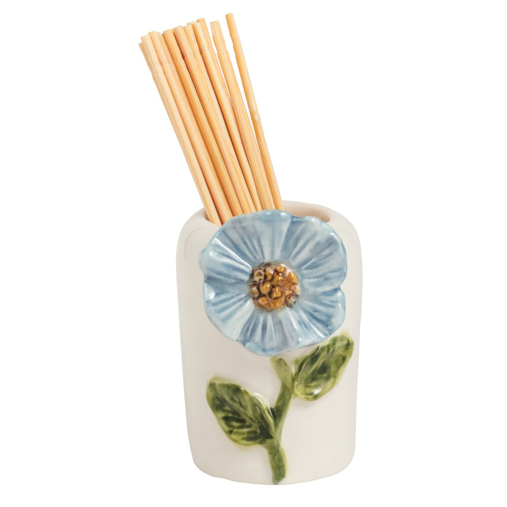 A ceramic toothpick holder featuring a blue flower and green leaves, filled with wooden toothpicks against a white background.