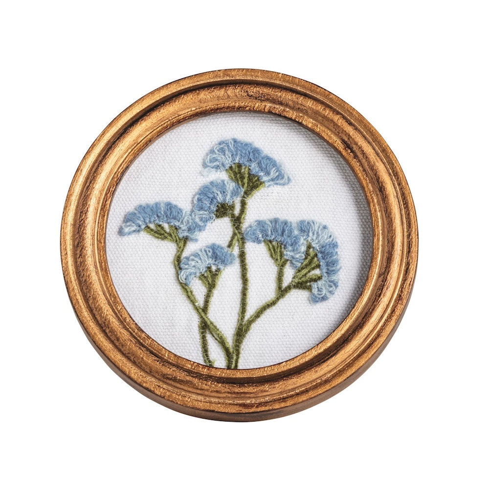Miniature round gold frame featuring a hand-embroidered blue wildflower bouquet on white canvas.