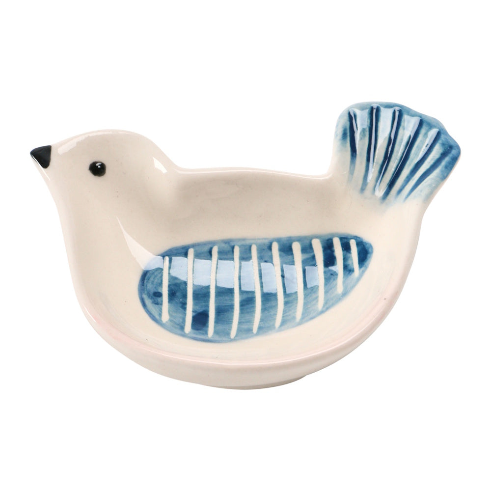 A small, bird-shaped ceramic dish, painted off-white with blue accents on the wing and tail, facing left.