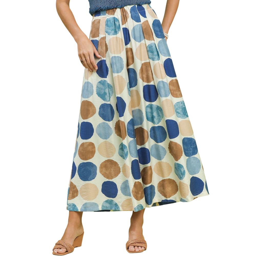 Woman wearing wide-leg pants featuring a large blue, light blue, and tan polka dot pattern.