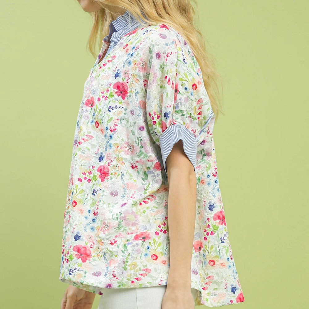 White jacquard floral print button-down top with short cuffed sleeves and a blue striped collar on a model.
