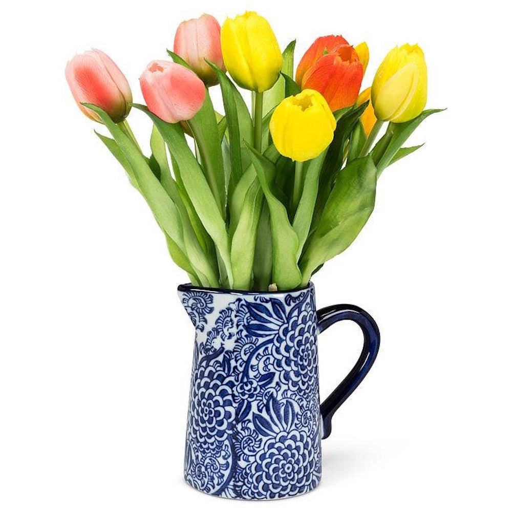 Colorful tulips bouquet in a blue and white ceramic floral jug vase.