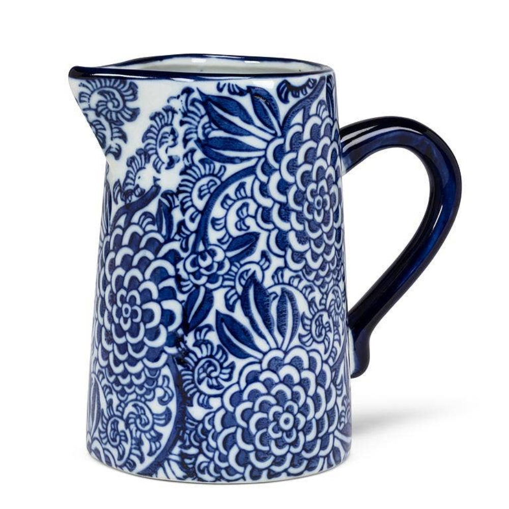 Blue and white ceramic floral jug with an ornate chanderi pattern and a solid blue handle on a white backdrop.