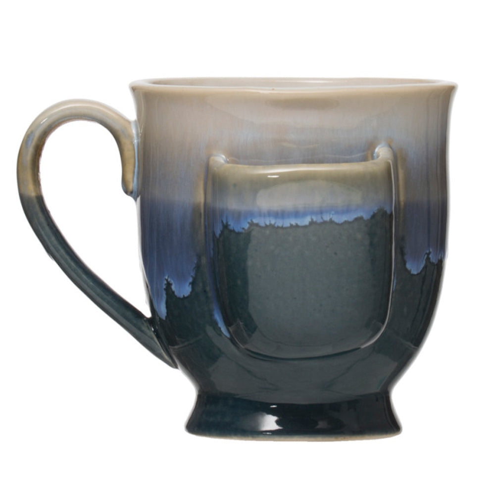 Blue stoneware tea mug with integrated tea bag holder pocket and a drippy cream and navy glaze finish.