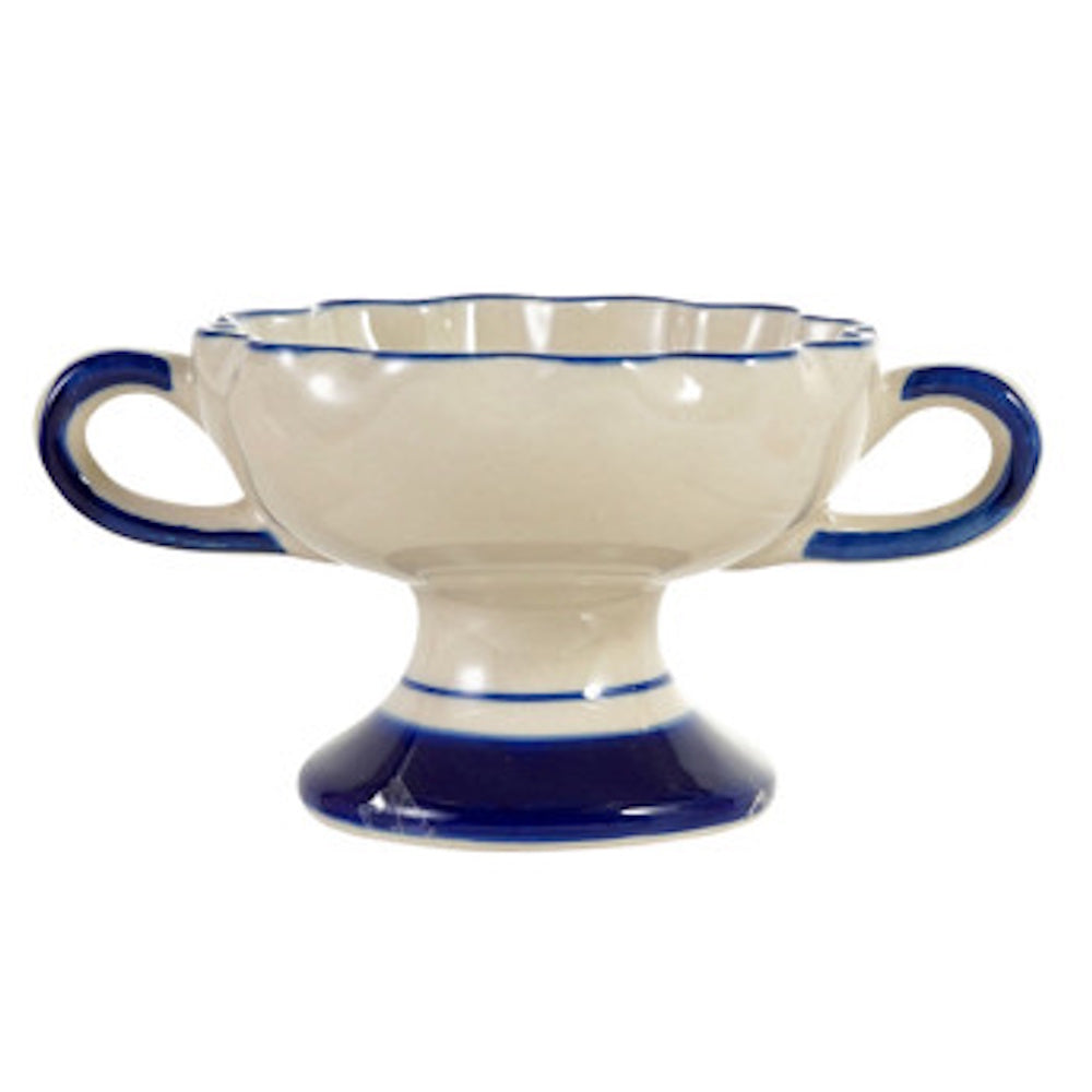 Scalloped ceramic footed bowl in cream with blue handles and trim on a white background.