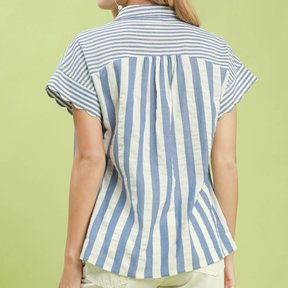 Back view of a woman wearing a blue and white striped collared top with short flutter sleeves.