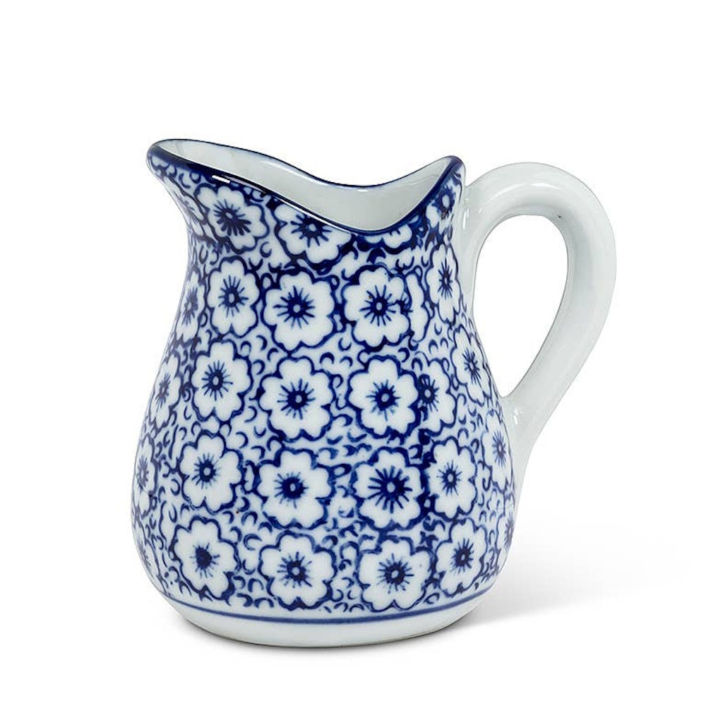 Blue and white ceramic flower pattern pitcher with a curved handle.