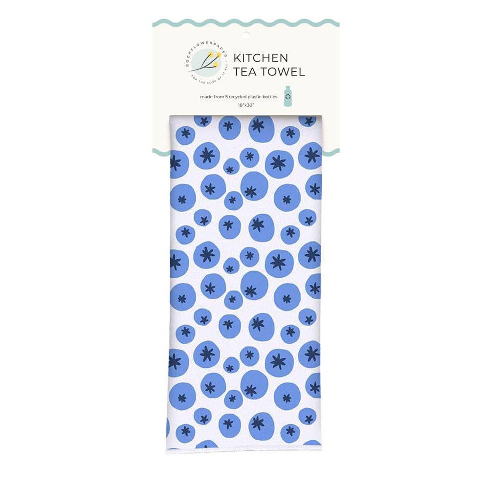 Folded kitchen tea towel with a blue blueberry pattern, displayed in its paper hanging packaging.