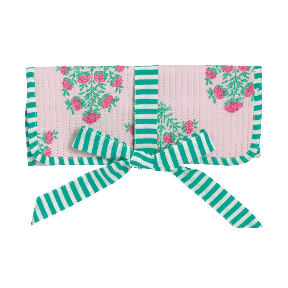 Pink floral block-print quilted jewelry roll with green striped ribbon tie closure on white background.
