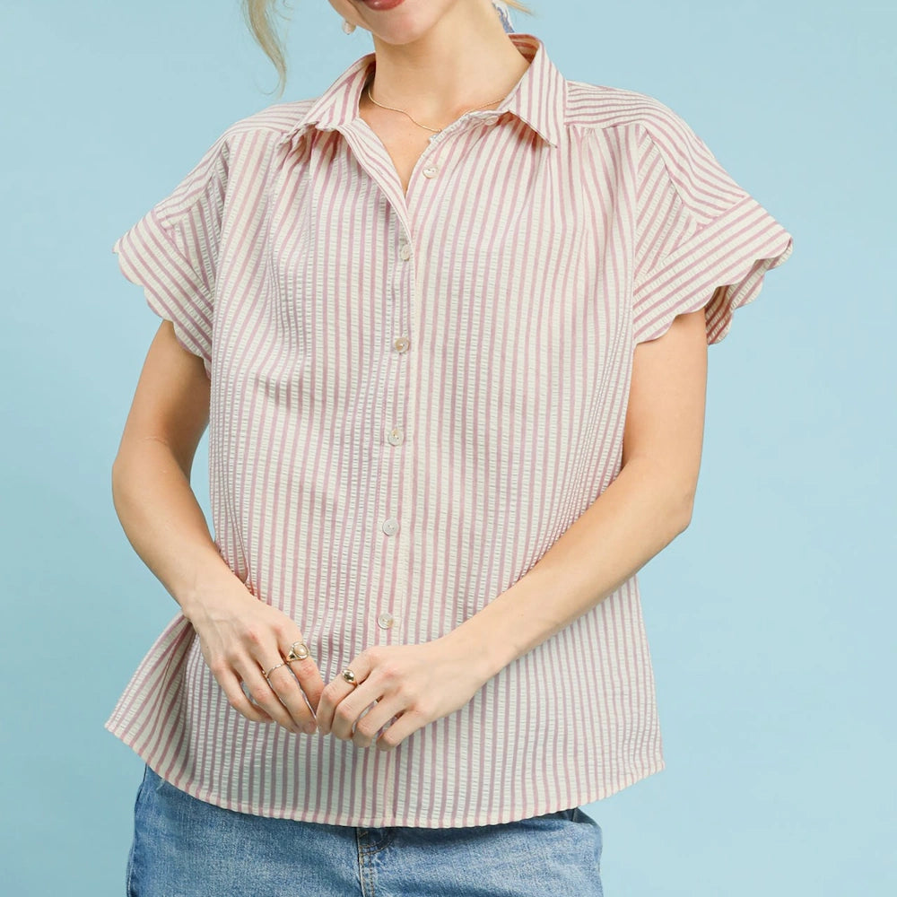 Blush pink and white striped button-down top with short scalloped sleeves and a collar, paired with blue jeans.