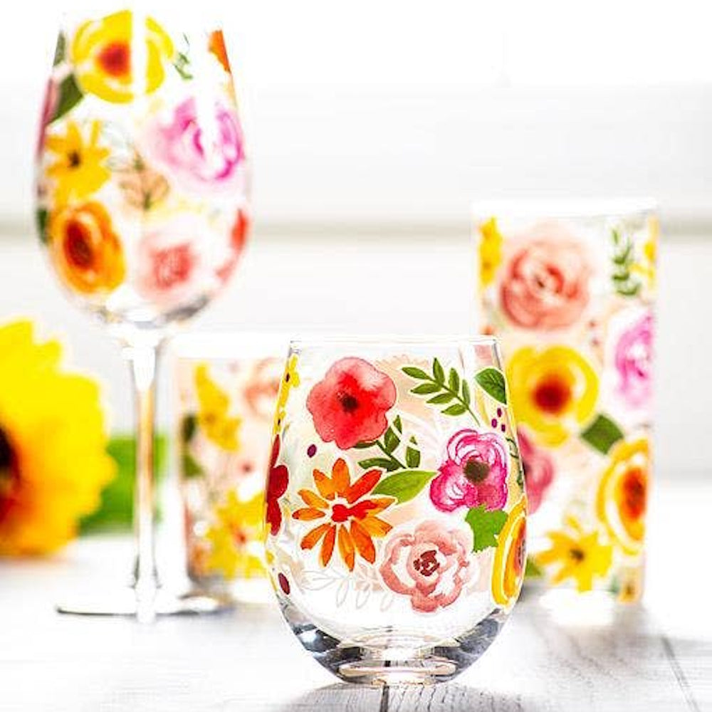 Hand-painted stemless and stemmed wine glasses with vibrant watercolor floral designs of poppies and roses.