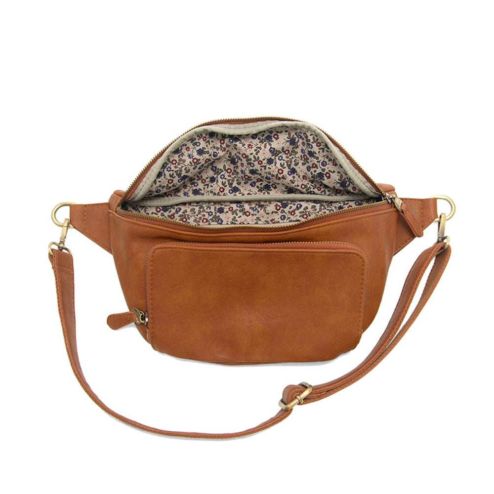 Open brown faux leather belt bag with floral print lining and adjustable crossbody strap on white background.
