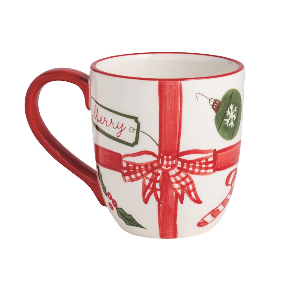 White ceramic mug painted to look like a Christmas present with a red plaid ribbon.
