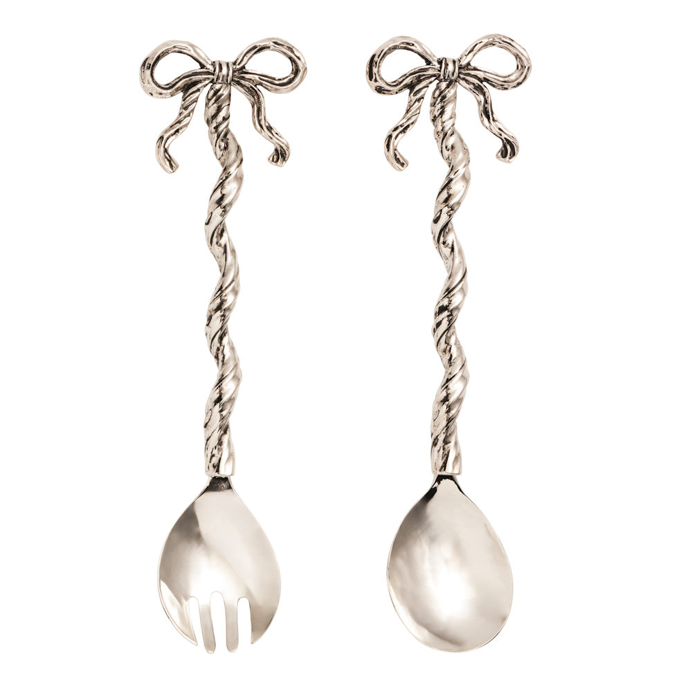 Silver bow serving utensil set with twisted handles and ribbon accents, including a salad fork and spoon on a white background.
