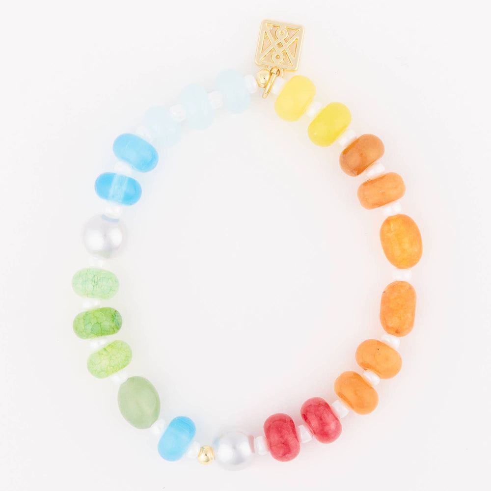 Beaded rainbow bracelet with colorful round stones, pearl accents, and a square gold charm on a white background.