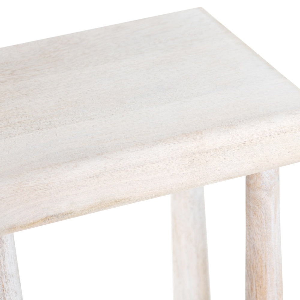 Close-up of a white washed wooden stool seat showing natural grain and tapered legs.
