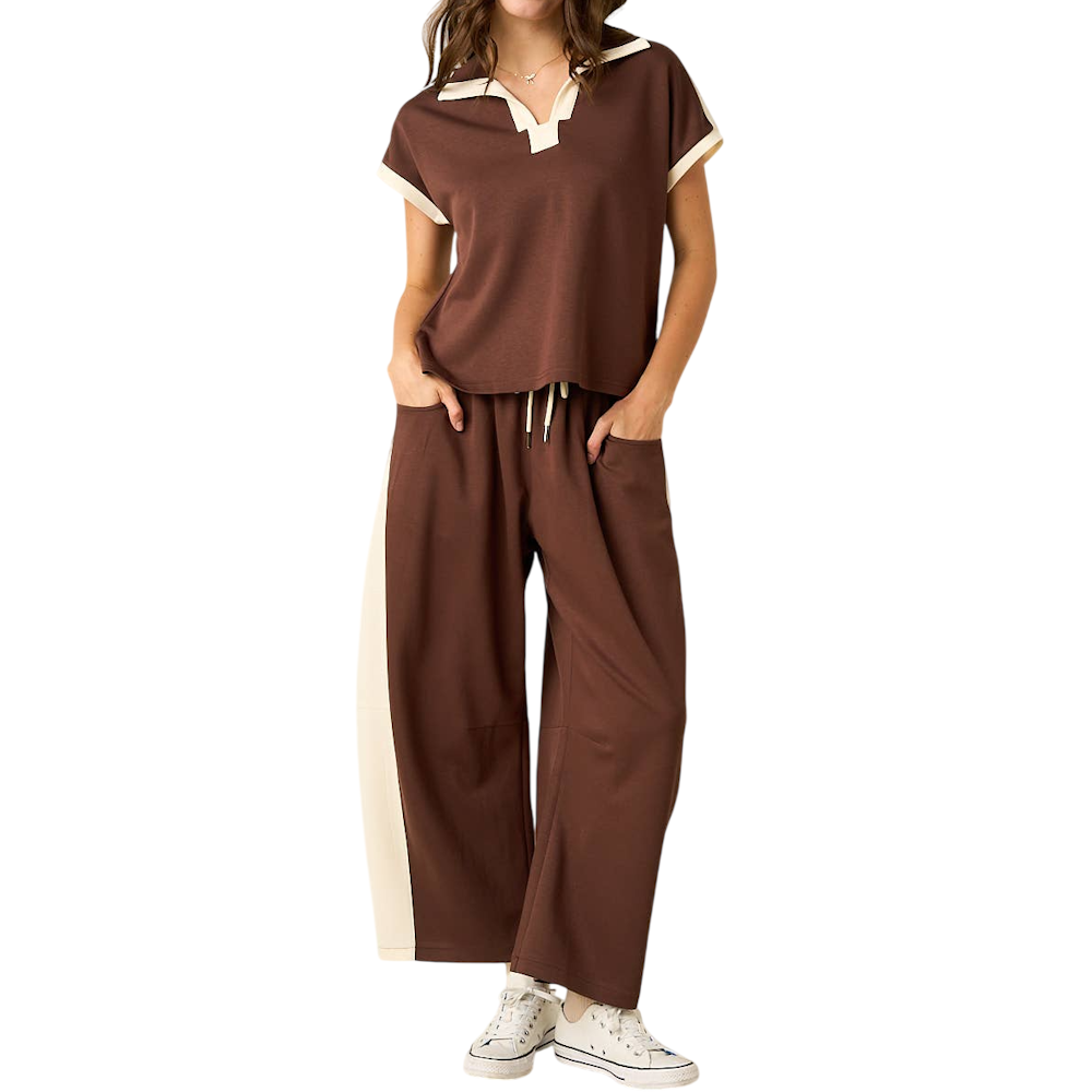 Woman wearing a brown short-sleeve polo top and matching wide-leg pants with ivory side stripes.