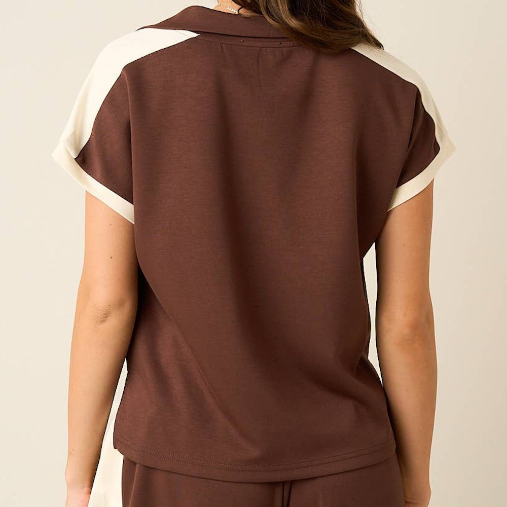 Back view of a brown short-sleeve polo top with cream contrast trim along the shoulders.
