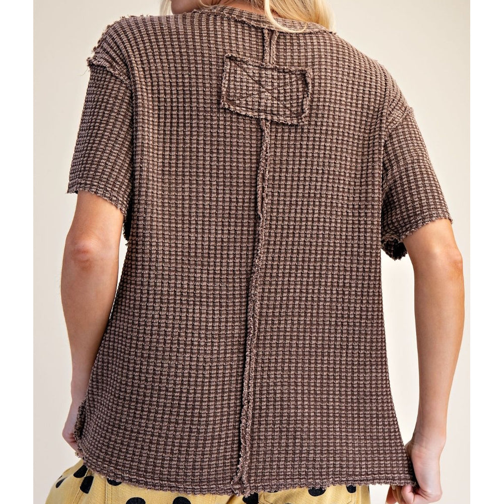 Back view of brown short-sleeve mineral-washed waffle knit top with raw-edge center seam detail.