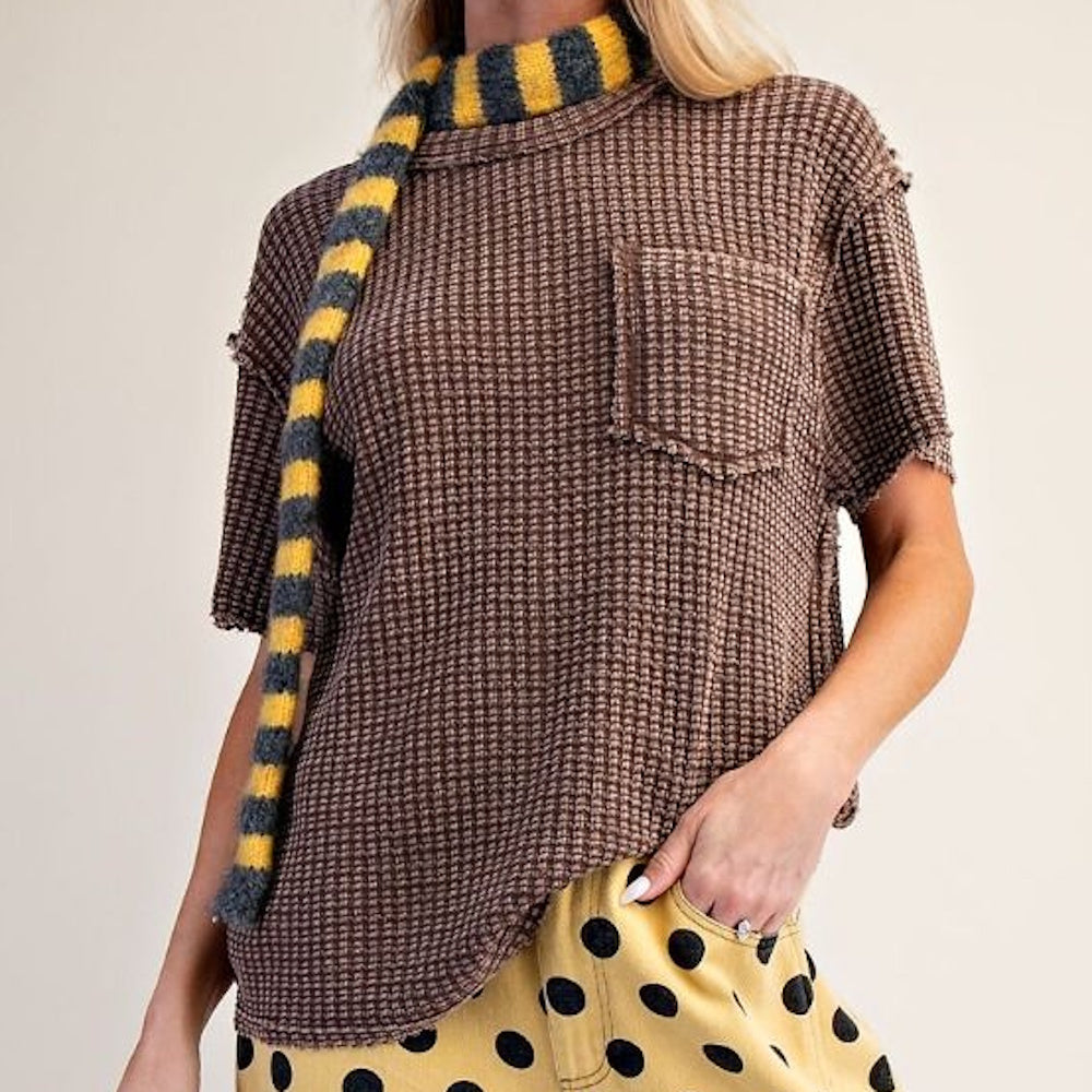 Front angled view of brown short-sleeve mineral-washed waffle knit top styled with striped scarf.